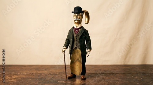 Whimsical character in formal attire holding cane on wooden surface