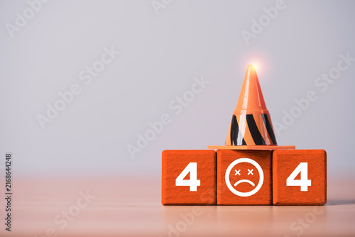 404 error concept with orange traffic cone and sad face on wooden blocks symbolizing broken links, missing web pages, website failure, technical problems, maintenance and online access errors.