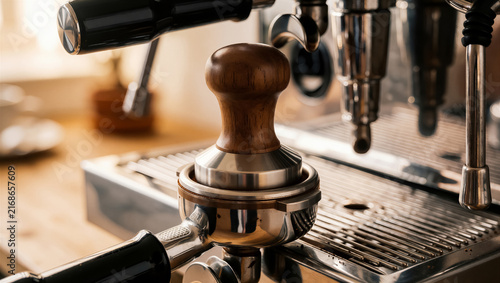 A professional espresso machine with portafilter and tamper, ready for fresh coffee brewing. Detailed shot highlights barista craft for quality beverage preparation
