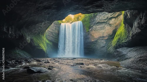 Majestic Waterfall Flowing Through a Cave Opening: Natures Hidden Gem.