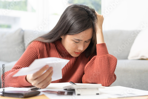 Quadro su tela Business financial concept, stressed asian young woman hand checking list with bill for calculate accounting expense credit card payment on due deadline, trying to find money to pay debt on table
