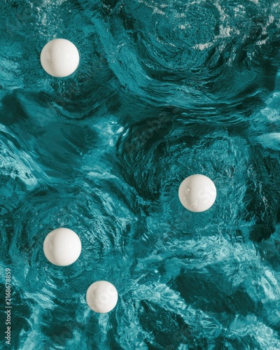 Four white spheres float on a turbulent, turquoise liquid surface