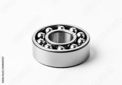 A single high-precision steel ball bearing featuring polished metallic spheres and rings, isolated on a pure white studio background, iron, orbit, object