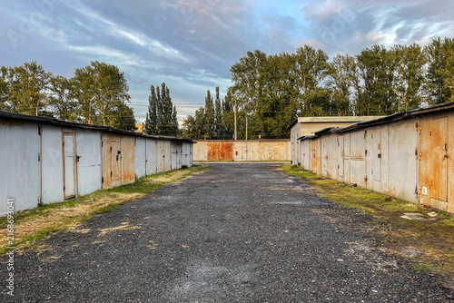 Old brick garages with metal gates. Garage cooperative for car storage. Typical complex of old garages.