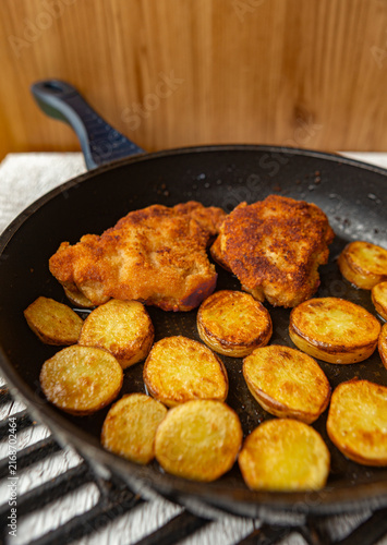 Breaded chicken schnitzel with pan-roasted potato slices.