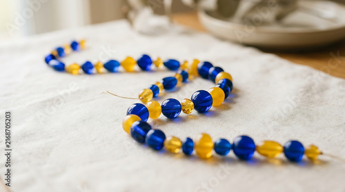 Arrangement of blue and yellow glass beads in a flowing pattern on a textured surface