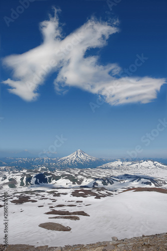 Foto Dragon shaped cloud floating over snowy Vilyuchinsky volcano cone view from Gore