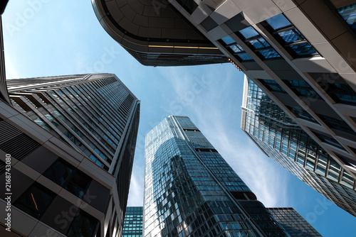 Low angle view of skyscrapers in Frankfurt am Main cityscape. Residential and office buildings against a blue sky, modern architecture, building exterior.