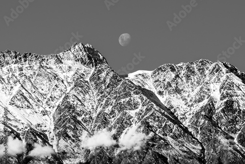 Photography Daytime moon above snowy mountain range in Queenstown, New Zealand