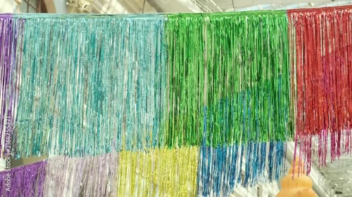 colorful tinsel garland hanging in rows for festive decoration. shiny foil garland creates joyful atmosphere for party celebration. bright garland is perfect decor for any holiday event