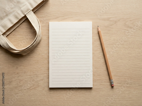 Blank paper notebook with a wooden pencil on a green desk
