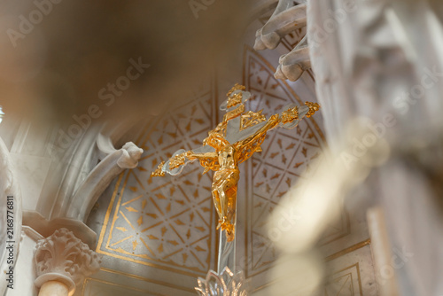 Holy mass in a catholic church. The ceremony takes place at the altar with Jesus on cross statue and religious symbols visible.