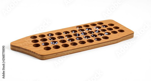 Wooden peg solitaire board game with tiny stars in holes, puzzle game concept, isolated on white background
