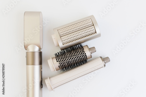 Small hair styling tool with multiple attachments on a white background