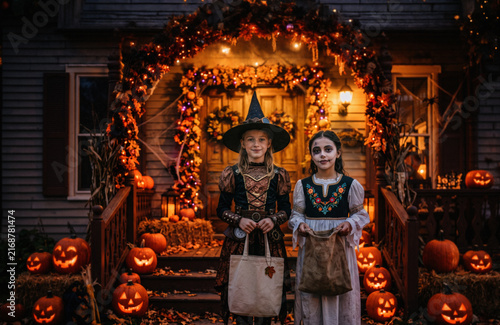 Halloween girls trick-or-treat at the dusk