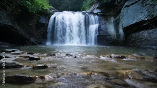 Mini waterfall flowing over shallow stones