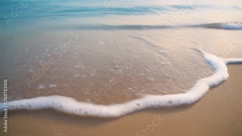 Slow-motion gentle ocean waves rolling over smooth sand