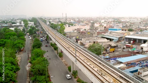 Aerial view of elevated metro expressway and urban cityscape in New Delhi, India.
