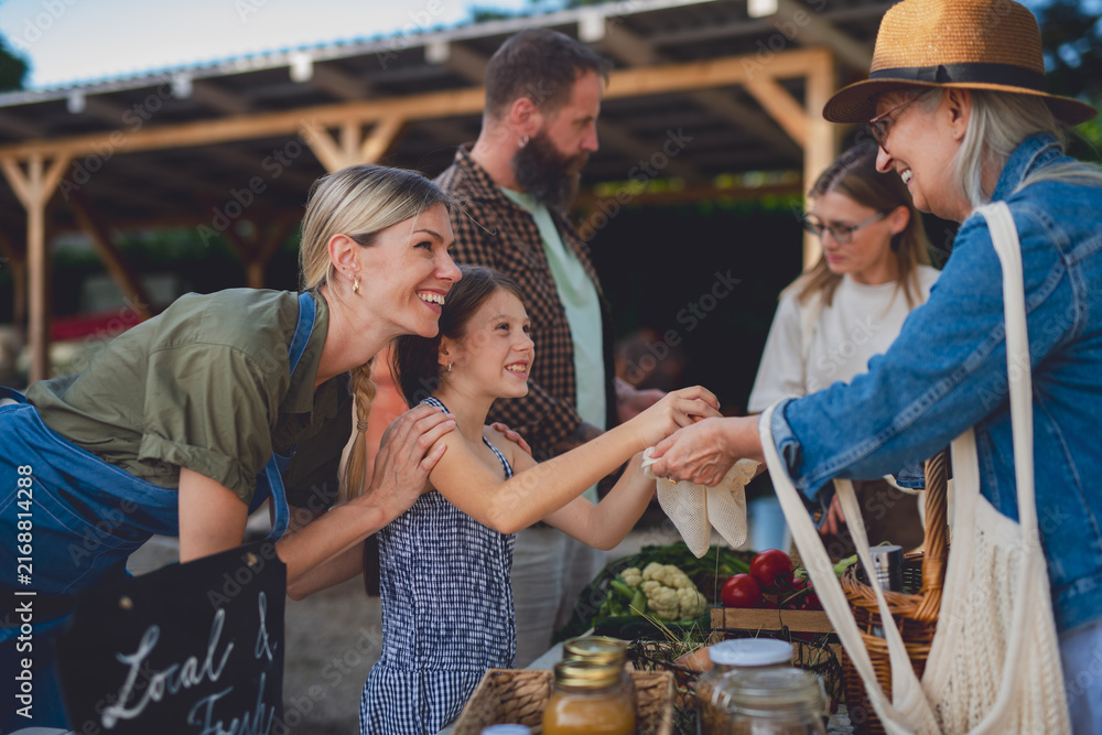 Fototapeta premium People shopping for fresh organic produce at local farmers market.