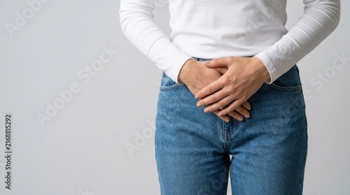 Woman holding her lower abdomen in pain or discomfort, suffering from pelvic health issues.