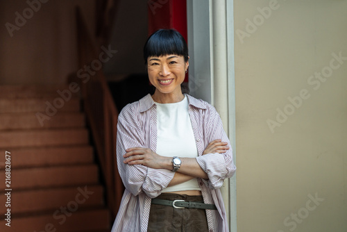 Confident asian woman smiling with arms crossed