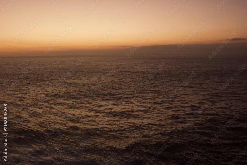 Obraz premium Dramatic Ocean Horizon at Sunset with Warm Golden Sky