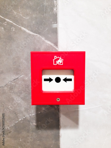 Obraz na płótnie Red manual fire alarm call point box mounted on a modern marble wall