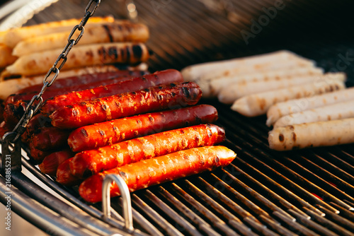 Canvastavla Several sausages are placed on a barbecue grill, with some grilled to a dark color while others remain lighter
