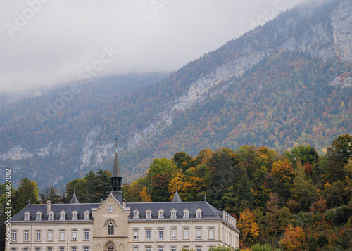 Historic Hospital Below Misty Chartreuse Mountain Cliffs