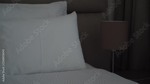 Turning a bedside lamp on and off in a cozy bedroom, evening routine and home comfort concept