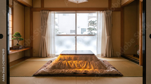 Cozy Japanese living room in winter with a warm glowing kotatsu table and tatami flooring