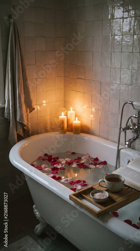 Freestanding Bathtub with Rose Petals and Candlelight in Dim Evening Bathroom