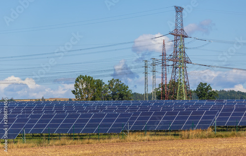Solar power farm with high voltage electricity pylons in Ceske Budejovice, Czech Republic.
