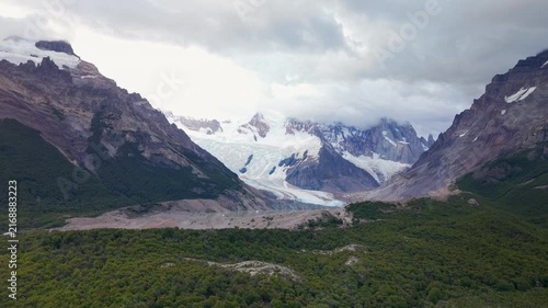 Majestic panoramic view of Glaciar Grande flowing into Laguna Torre in Los Glaciares National Park, Patagonia, Argentina. Features dramatic clouds over the snowy Cerro Torre massif and iceberg