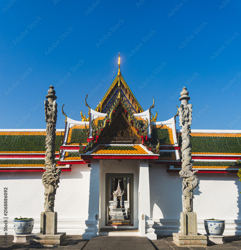 Obraz premium Symmetrical Entrance Gate Flanked by Carved Stone Dragon Pillars at Wat Arun Temple in Bangkok Thailand