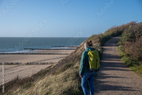 Hiker on a coastal trail overlooking the North Sea in Westkapelle, Netherlands