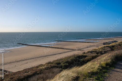 Coastal hiking trail and sandy beach with wooden groynes in Westkapelle, Netherlands