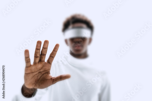 Фотография Person in VR headset with hand raised, blurred futuristic vibe