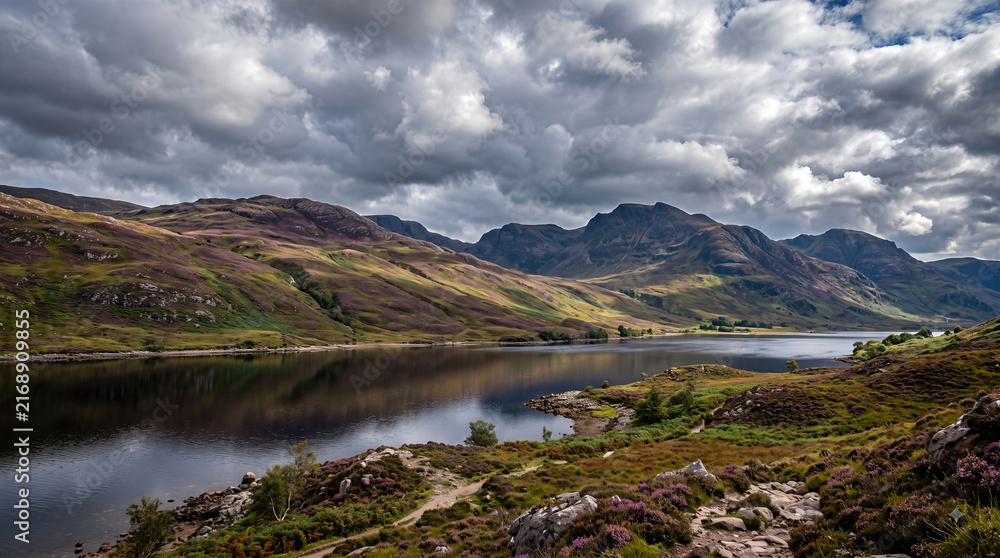 Obraz premium Dramatic moody clouds over scenic Scottish lake and mountain landscape in summer