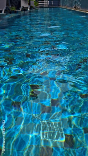 Sunlit Swimming Pool Water with Ripples and Tiles