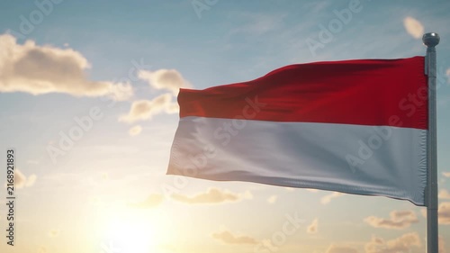 Indonesian Flag Waving Against Blue Sky at Warm Sunset
