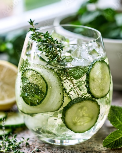 Refreshing green cocktail glass with cucumber slices and fresh herbs leaf