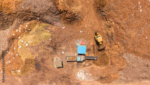 Konstfotografi Coconut husk waste segregation yard with an excavator moving coir and pith