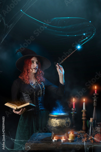 Canvas Print Witch with magic wand casts spell, cauldron, boiling magic potion, candles