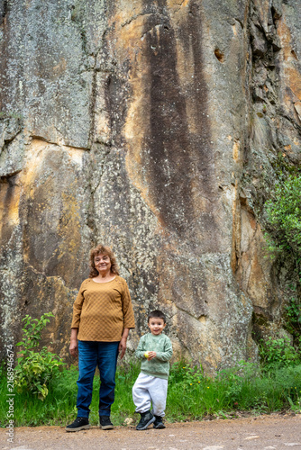 Grandmother and grandson smiling together against a rocky cliff in Mineral del Chico, Mexico.