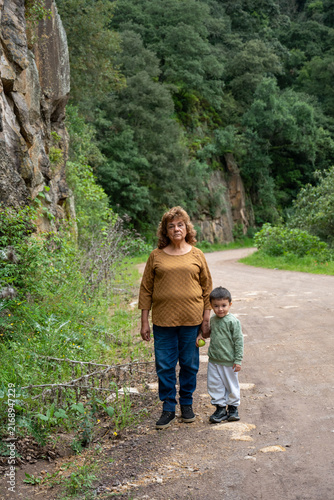 Abuela caminando con su nieto por un camino de tierra en Mineral del Chico, Hidalgo, México.
