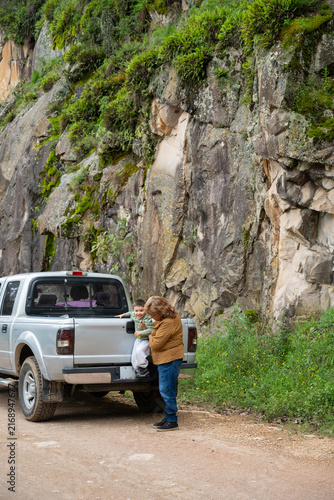 Grandmother helping her grandson onto the back of a pickup truck in Mineral del Chico, Mexico.