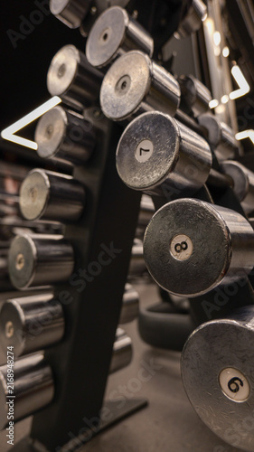 Fotografie Gym dumbbells neatly arranged on a rack, ready for a workout session