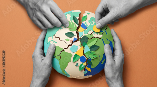 Grayscale hands repairing paper globe with leaves and colorful shapes in tactile environmental collage