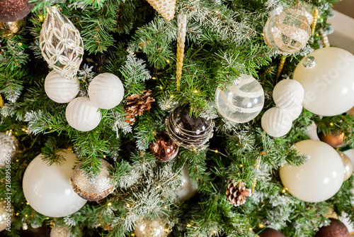 Decorating Christmas tree on bright background, White Christmas ball toy.Merry Christmas, Scandinavian style. Christmas decor. ornaments and garland lights, Christmas holidays background.